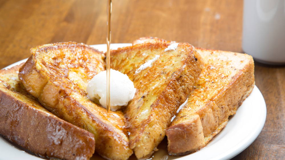 plate of french toast with syrup being poured on top
