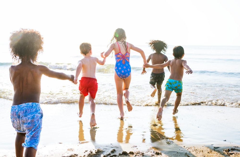 kids running into ocean