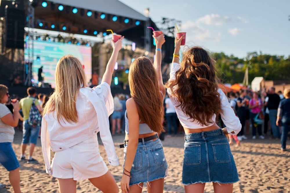 3 women at a beach concert