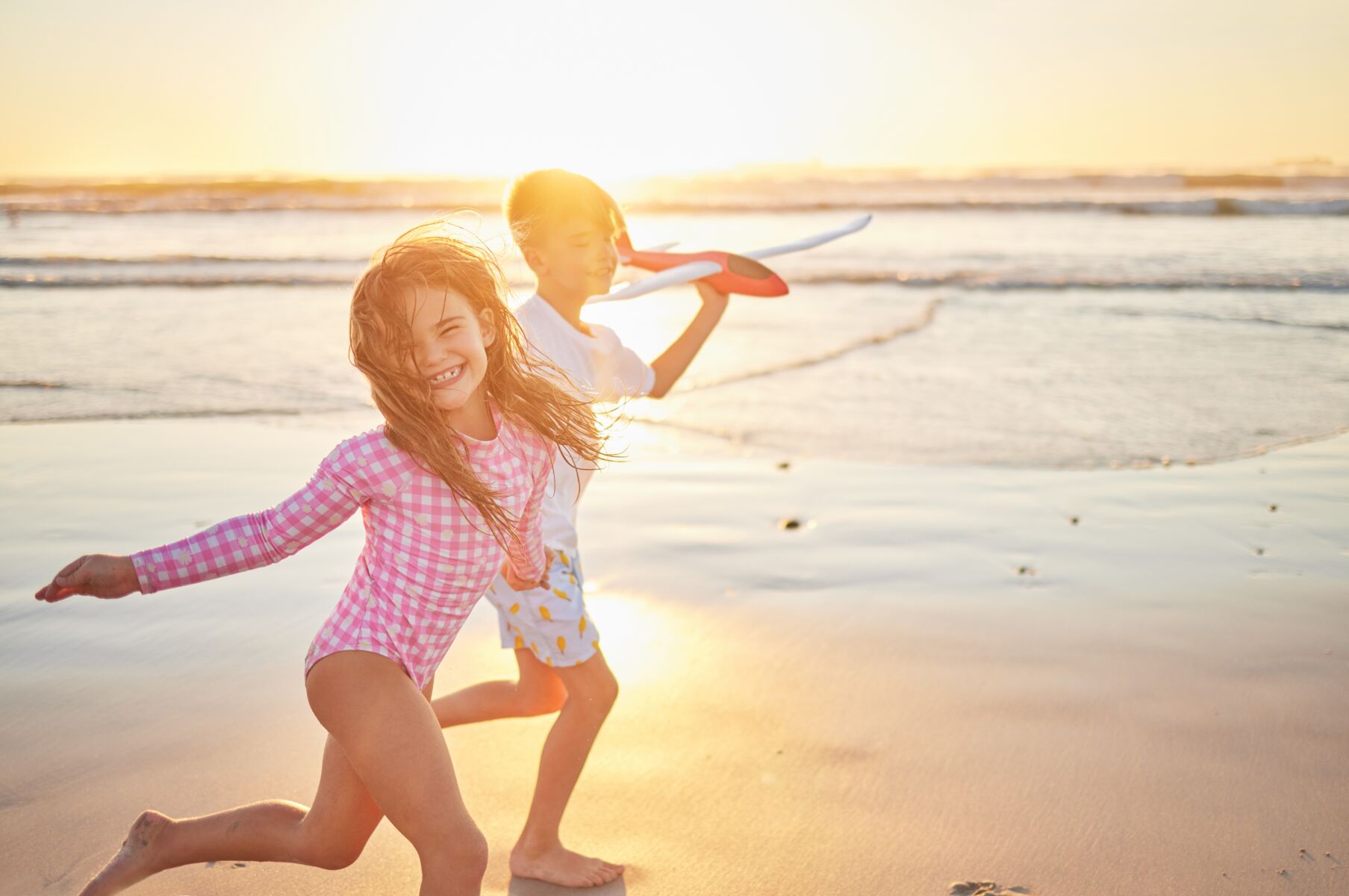 kids running on beach at sunset